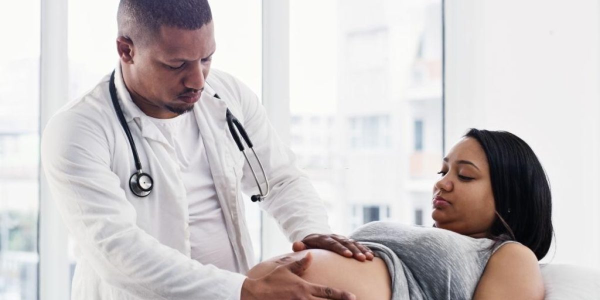 Shot of a young doctor examining a pregnant woman during her routine checkup at a clinic